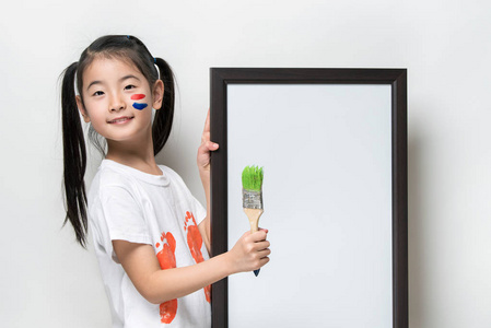 漂亮的亚洲小女孩用画笔和白色的旗帜