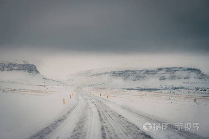 以雪山为背景 以冰冻道路为前景的暴风雪期间冰岛公路冬季景观照片 正版商用图片0nhlpp 摄图新视界