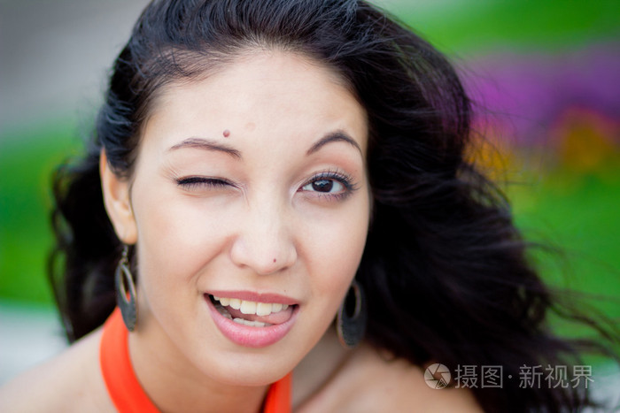 年轻快乐的黑发女人眨着眼睛