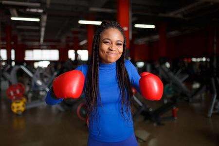 非洲美女拳击手在健身房训练穿着红色手套