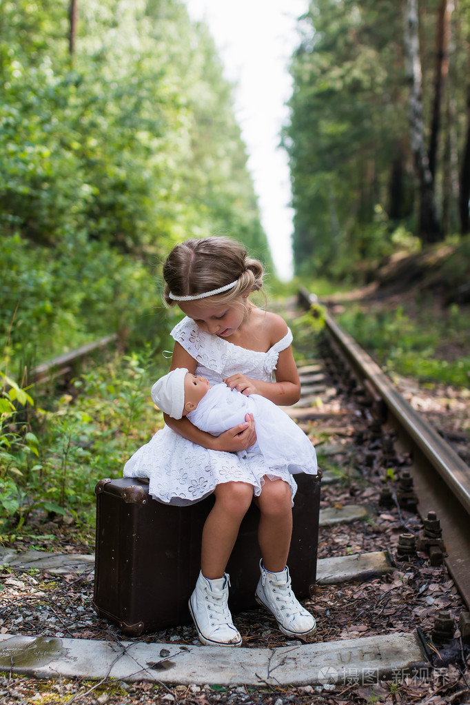她怀里抱着一个洋娃娃的小女孩