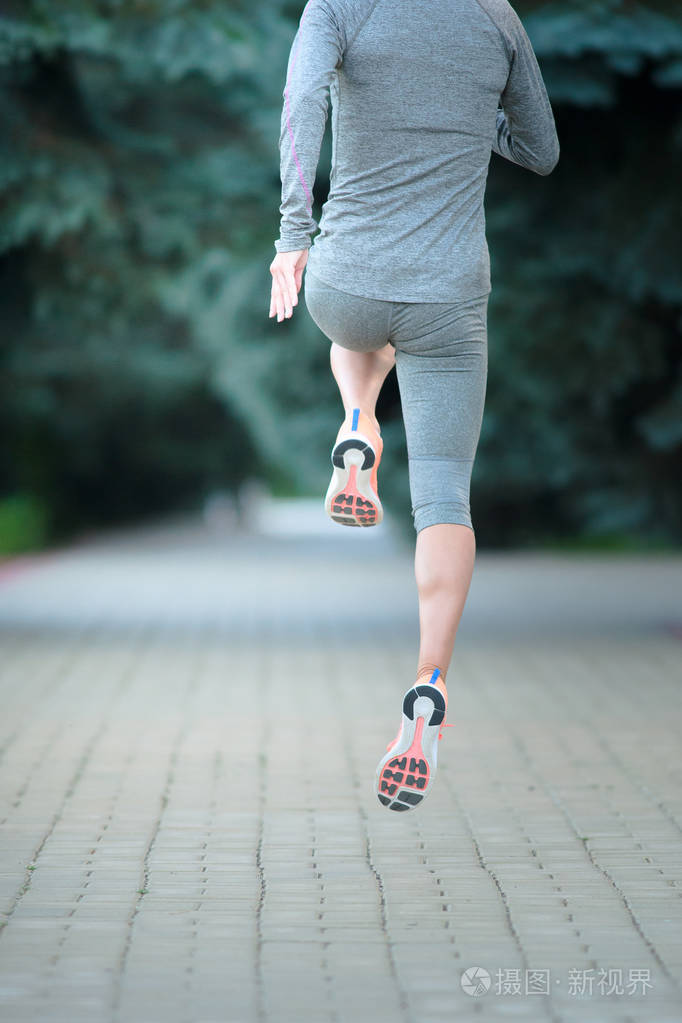 在道路上运行的跑步运动员.女人健身慢跑锻炼我们