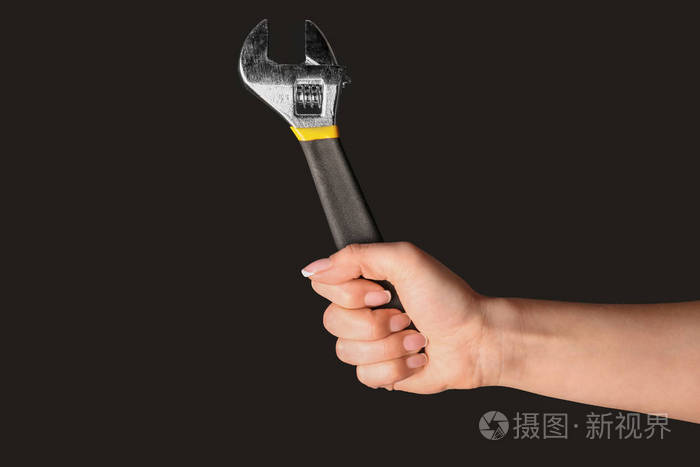 黑色背景可调式扳手的女车技工手