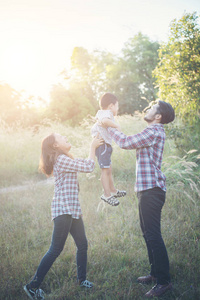 快乐的年轻家庭花时间一起在外面绿色 natur
