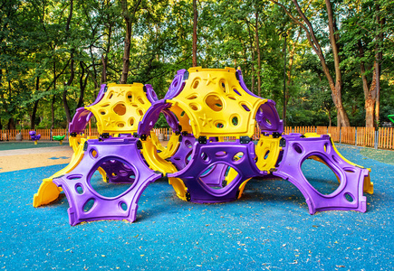 在公共公园包围的院子里活动的儿童游乐场照片