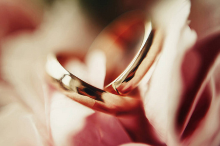 模糊的图片金色结婚戒指躺在婚礼花束玫瑰