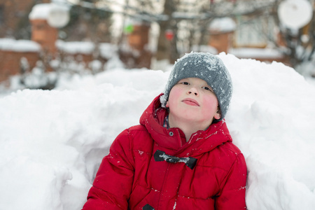 一个可爱的男孩，在冬天玩雪洞中