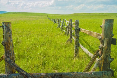 对农村旧木栅栏的看法。夏日围栏在田野上奔跑的线性透视