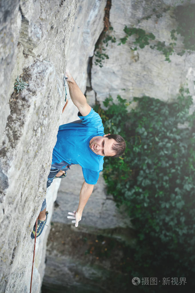 摇滚男登山者在悬崖上