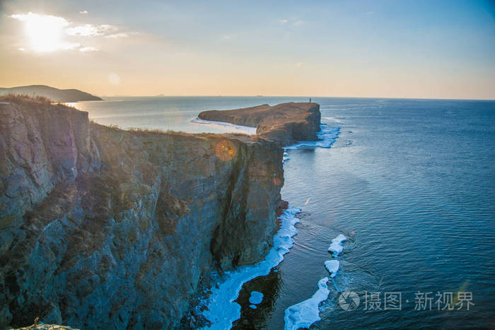 高高的悬崖进入大海, 全都在冰上.峭壁在冰的日落.