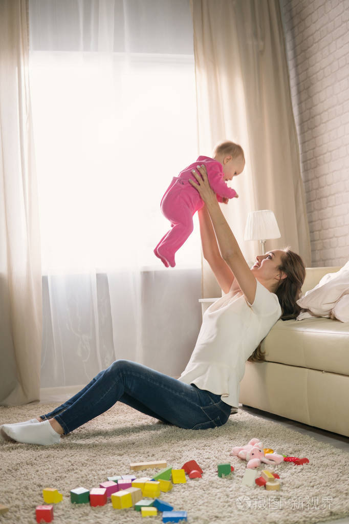 年轻母亲玩弄婴儿