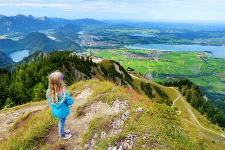 可爱的小徒步旅行者从 Tegelberg 山欣赏风景如画的风景