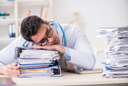 在医院工作太多的忙碌的医生照片