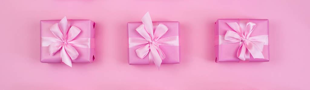 横幅装饰节日礼品盒粉红色的背景粉色的颜色。平面平顶视图