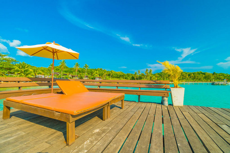 在美丽的热带海滩和海洋与椰子棕榈树在天堂岛的旅行和假期的雨伞和椅子