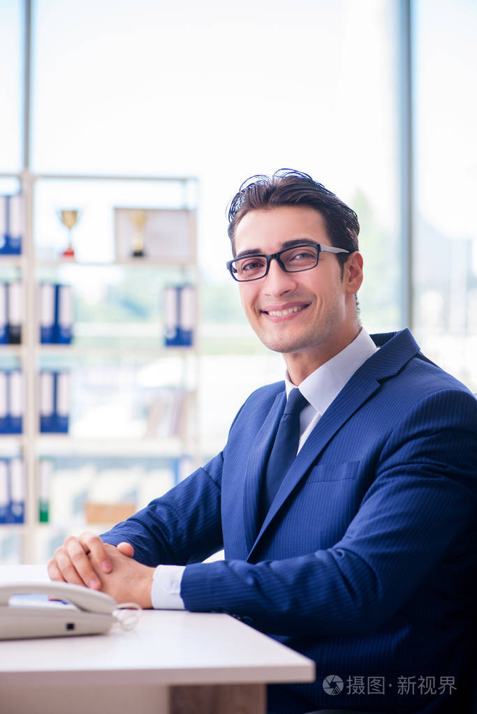 年轻英俊的生意人员工在办公室工作在办公桌上