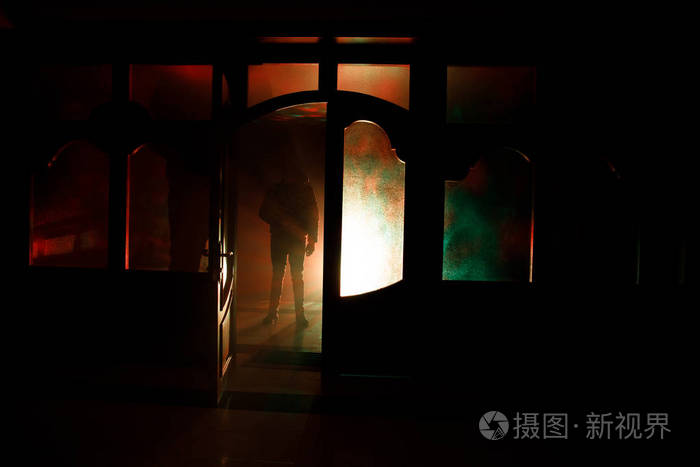 一个人在夜晚的窗口前的剪影.恐怖场面万圣节模糊轮廓的疯子的概念