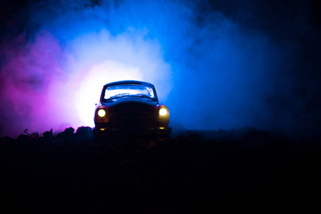 老老式汽车的剪影在黑暗的雾色调的背景与发光灯在低光, 或老犯罪汽车黑暗背景的剪影。选择性聚焦