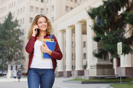 美丽的女学生站在大学校园前图片