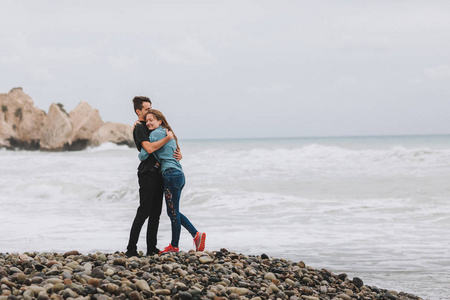 爱的情侣在海滩上散步, 亲吻和玩乐, 在岩石和海洋附近的婚礼仪式