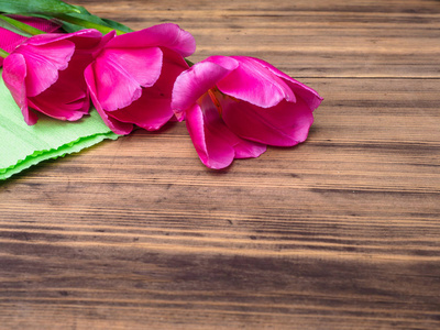 粉红色的郁金香，插花木制背景上用绿色的纸和空间的消息。3 月 8 日母亲节的背景和其他的贺卡或请柬为可爱的女人。软焦点