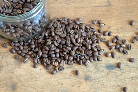 烘培的咖啡豆散落在木桌顶视图特写