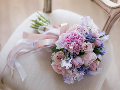 特写照片的婚礼花束与美丽的粉彩粉红色和紫色的花朵在轻复古椅背景