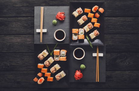 一整套寿司寿司和黑色仿古木 顶视图上卷