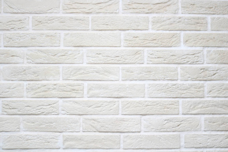 质地的浅米色划伤浮雕砖墙与白色接缝和矩形砖从装饰石膏.的背景照片