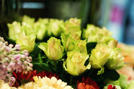 玫瑰 多彩玫瑰和其他鲜花在花店的入口处的花束，花束装饰在花店，许多在市场中的花，花在农贸市场