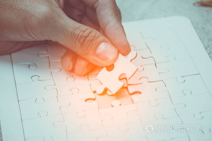 手捧白夹具的部分锯拼图和投入填补空白点;成功理念