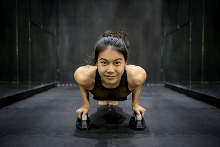 年轻的亚洲运动员女人做推在地板上
