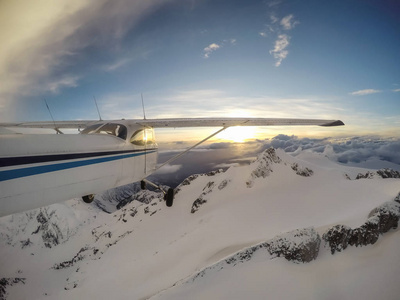 在充满活力的日落期间, 飞越加拿大山地景观的小型飞机。在加拿大不列颠哥伦比亚省温哥华以北的 Squamish 附近拍摄