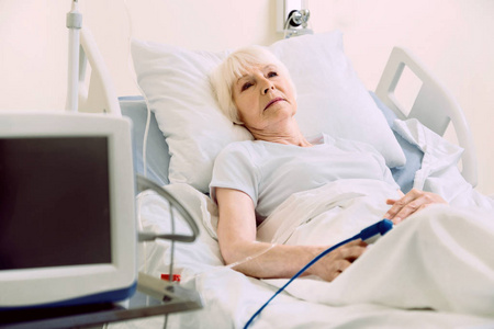 用脉冲脉搏躺在床上的沉思女性病人照片