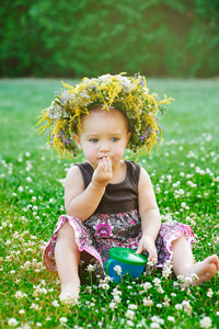 小女孩坐在草地上他头上的花环