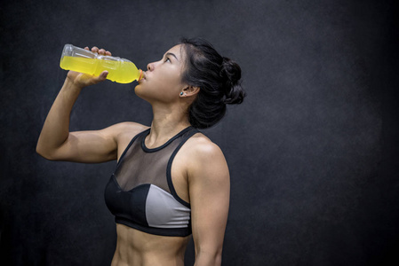 年轻的亚洲运动员女人喝运动饮料