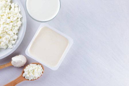 各式乳制品上的白色板, 平房干酪, 奶油和软奶酪白色背景, 牛奶在玻璃, 软奶酪三明治, 木制餐具, 复制空间