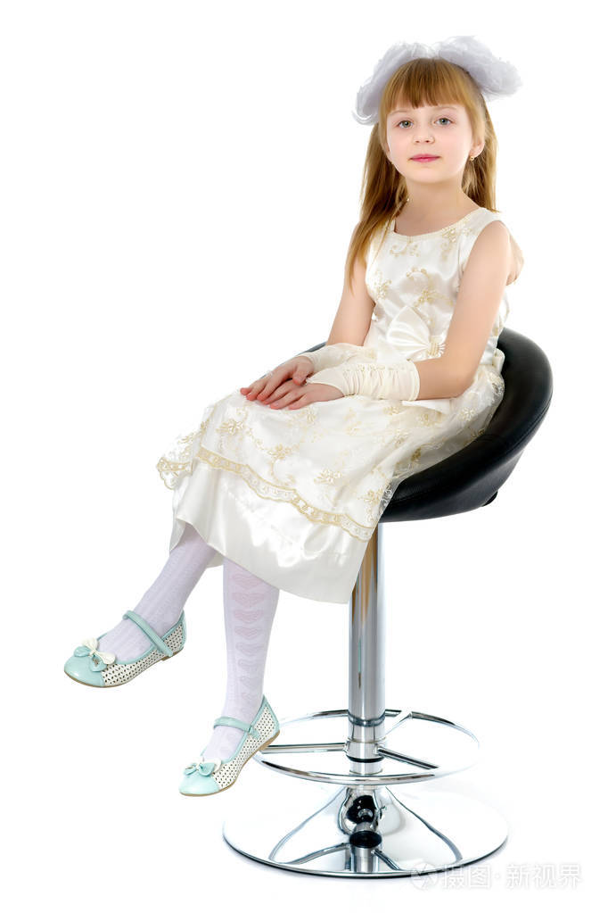 小女孩正坐在椅子上