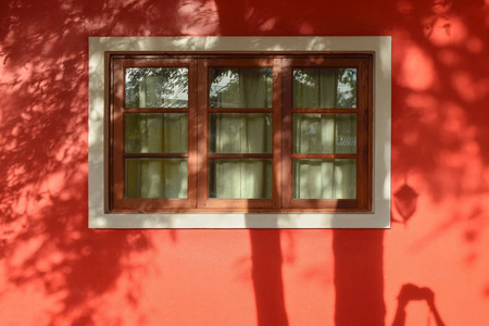窗口的红房子和假和树在墙上的影子