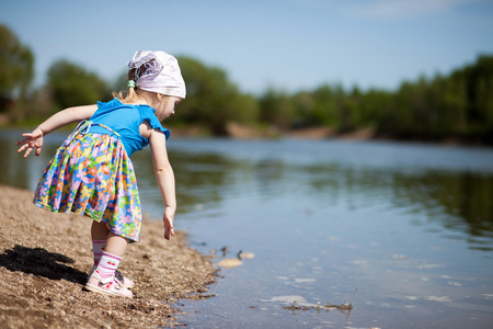 小女孩到湖里扔石头照片