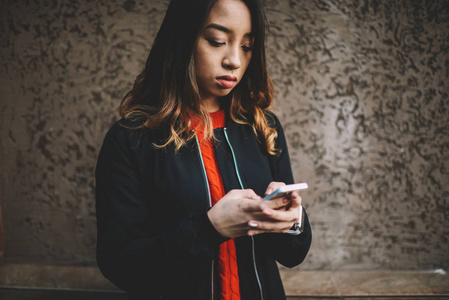 时尚的年轻时髦的女孩时髦的休闲服装发送信息在网络上聊天, 亚洲青年妇女在现代智能手机上使用良好的互联网连接更新应用程序