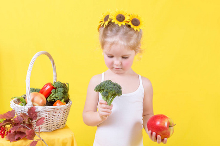 美丽的小快乐女孩与篮子蔬菜和果子