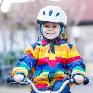 孩子安全头盔和 outd 多彩雨衣骑自行车的男孩