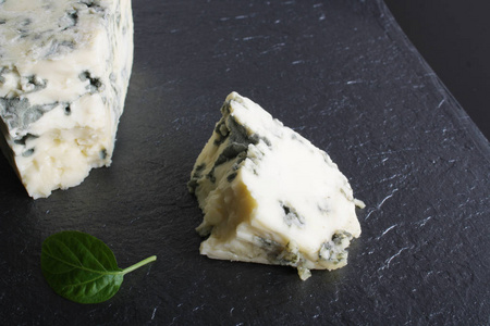 蓝色乳酪在石头背景黑