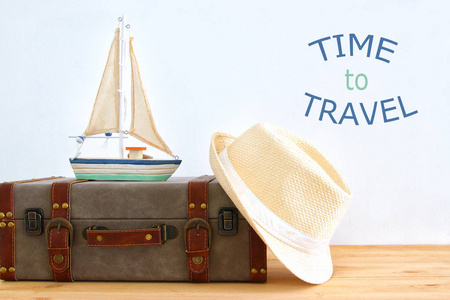 旅行者古董行李, 小船和软呢帽帽子在木桌。假日和假期概念