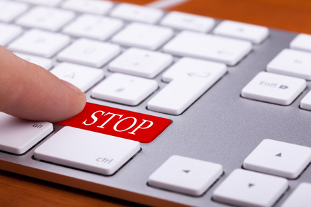 现代键盘上的手指推红色停止按钮