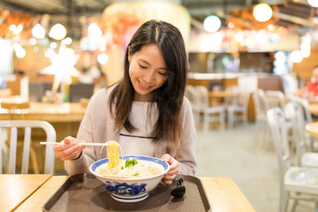 女人在餐馆里吃拉面