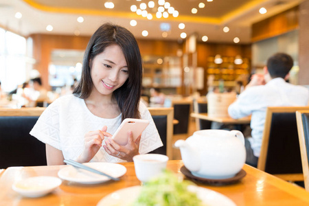 女人在中国餐馆使用手机