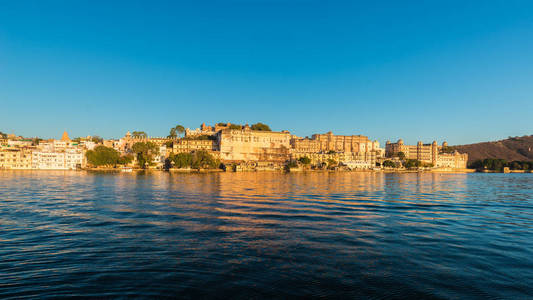 乌代浦市容在日落时。宏伟的城市宫殿在 Lake Pichola，印度拉贾斯坦邦的旅游胜地