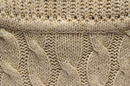 针织毛衣的质地。与电缆针织图案的毛衣相邻的区域。空白背景